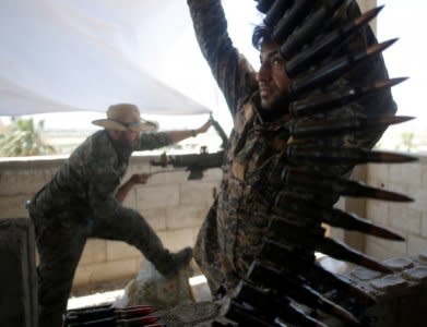 A Kurdish fighter from the People's Protection Units (YPG) carries ammunition in Raqqa, Syria June 21, 2017. REUTERS/Goran Tomasevic