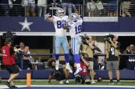 Dallas Cowboys tight end Dalton Schultz (86) and wide receiver Amari Cooper (19) celebrate a touchdown catch made by Schultz in the first half of an NFL football game against the Philadelphia Eagles in Arlington, Texas, Monday, Sept. 27, 2021. (AP Photo/Michael Ainsworth)