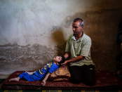 Der Syrer Ahmed kümmert sich um seine Tochter Reem, die bei einem Angriff der syrischen Streitkräfte schwer verletzt wurde und seither mit Behinderungen leben muss. (Bild: Mahmoud Al-Hamza/EPA)