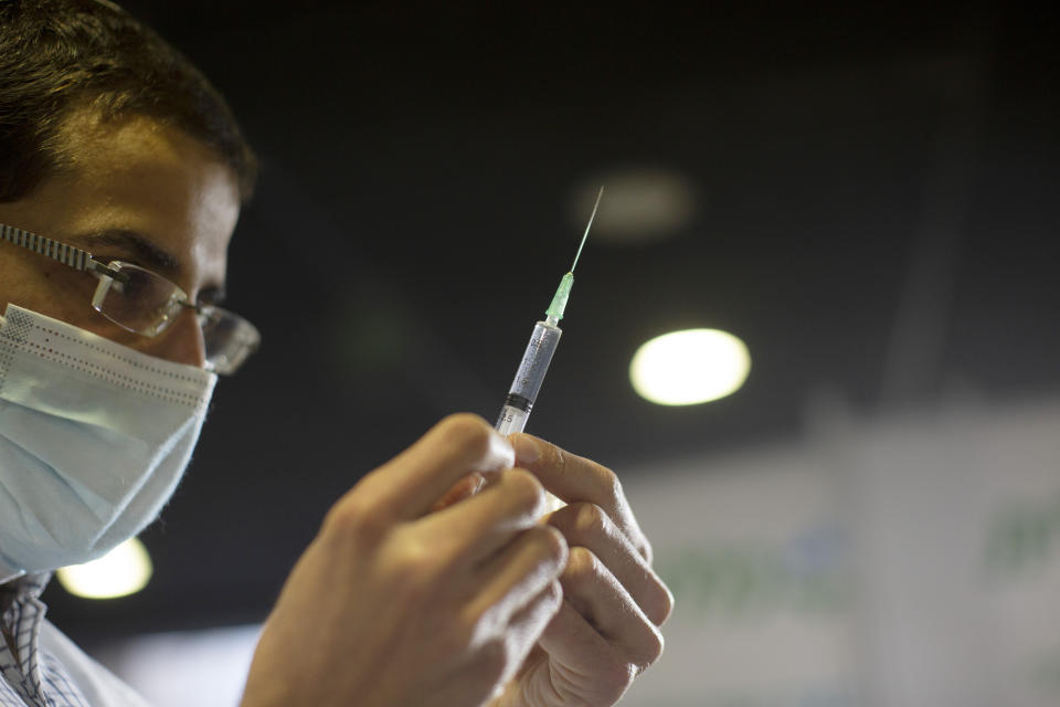 A medical professional prepares a syringe to administer the coronavirus vaccine a sports arena in Jerusalem, Wednesday, Dec. 30, 2020. (AP Photo/Maya Alleruzzo)