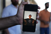 A Palestinian man Youssef al-Sayyed, shows through his mobile phone a picture of his brother Road, 15, who informed that he found dead at a hospital in the Syrian city of Tartus, after he was on a boat carrying migrants from Lebanon that sank in Syrian waters, as he waits to receive his dead body, at Arida border crossing point between Lebanon and Syria, north Lebanon, Sept. 23, 2022. Syria's health minister says several people have been killed from a boat that sank migrants from Lebanon off Syria's coast. The incident is the deadliest since a surging number of Lebanese, Syrians, and Palestinians have tried to flee crisis-hit Lebanon by sea to Europe. (AP Photo/Bilal Hussein)