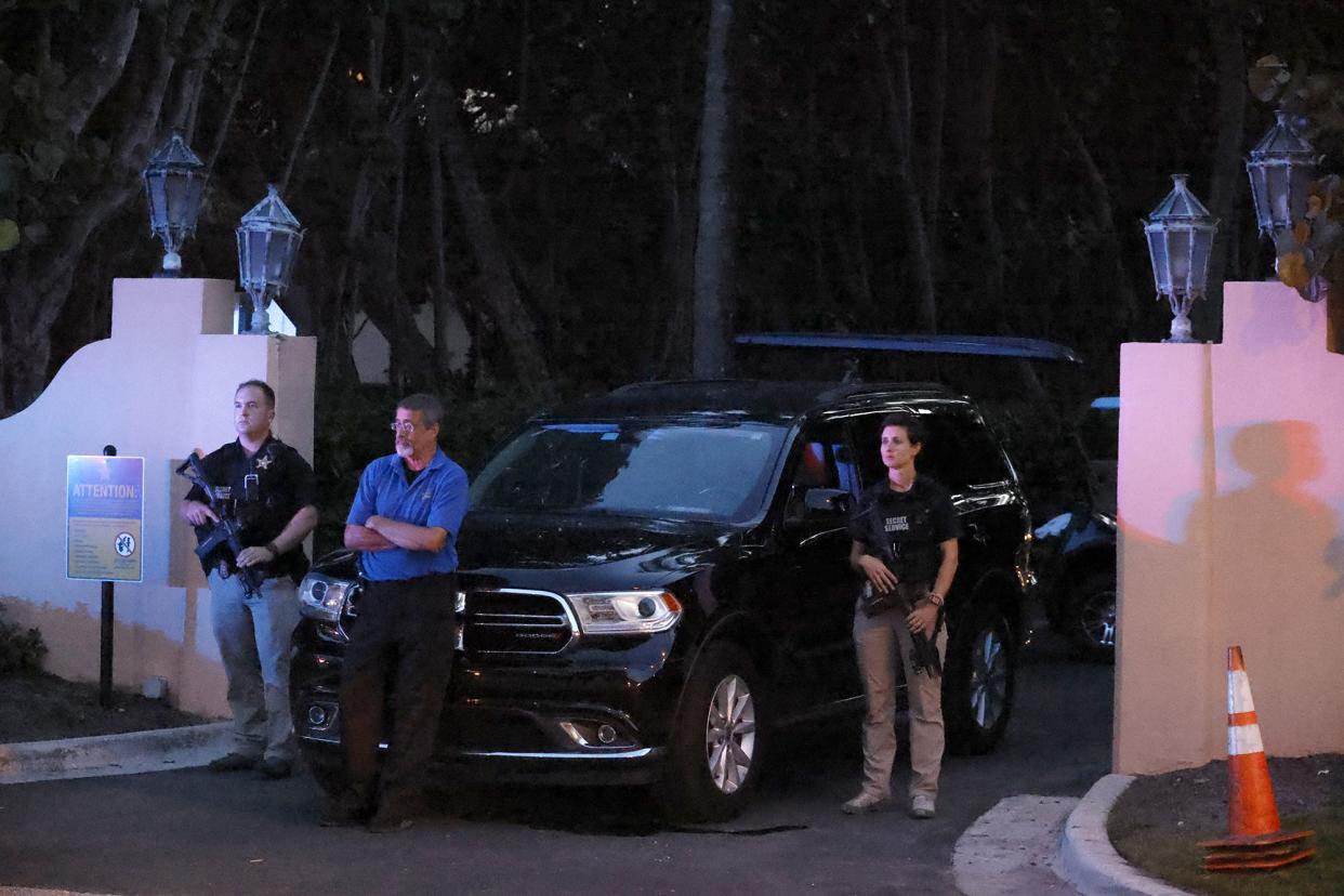 Armed Secret Service agents stand outside an entrance to former President Donald Trump's Mar-a-Lago estate, late Monday, Aug. 8, 2022, in Palm Beach, Fla. 