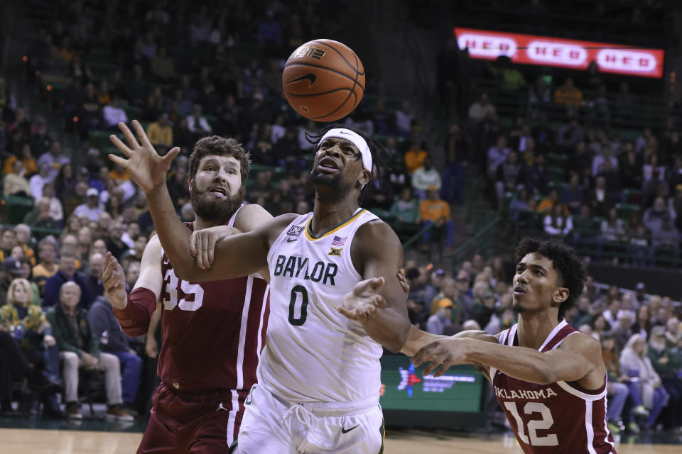 Baylor forward Flo Thamba (0) reaches for the ball in front of Oklahoma forward Tanner Groves (35) and guard Milos Uzan (12) during the first half of an NCAA college basketball game Wednesday, Feb. 8, 2023, in Waco, Texas. (AP Photo/Rod Aydelotte)
