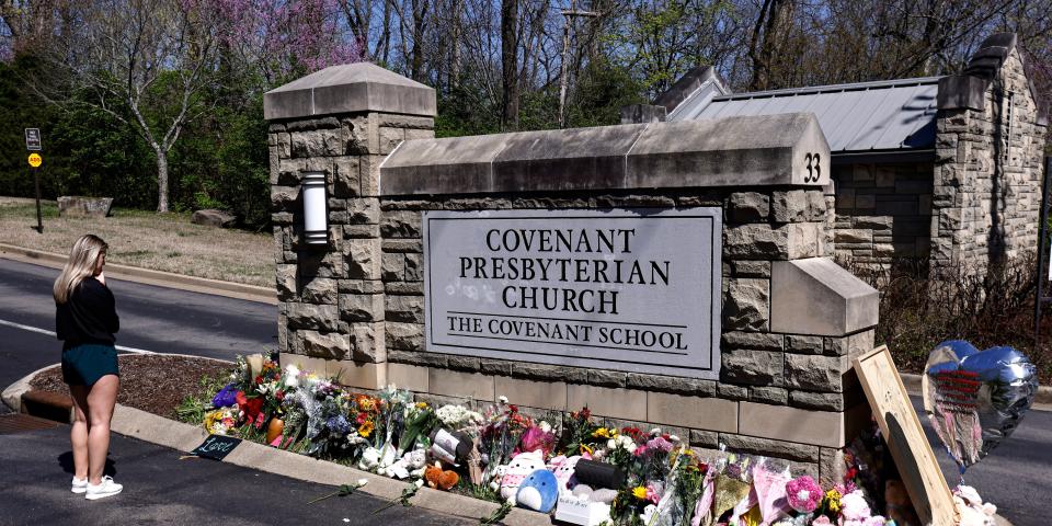 A woman stands in front of a sign for The Covenant School.