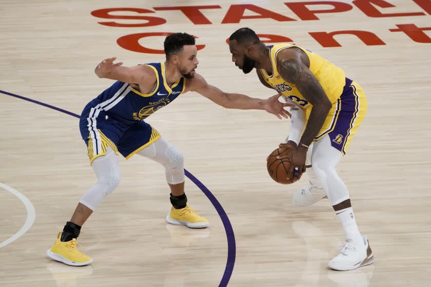 Golden State Warriors'  Stephen Curry, left, pressures Los Angeles Lakers'  LeBron James during the first half of an NBA basketball game, Monday, Jan.  18, 2021, in Los Angeles.  (AP Photo/Jae C. Hong)