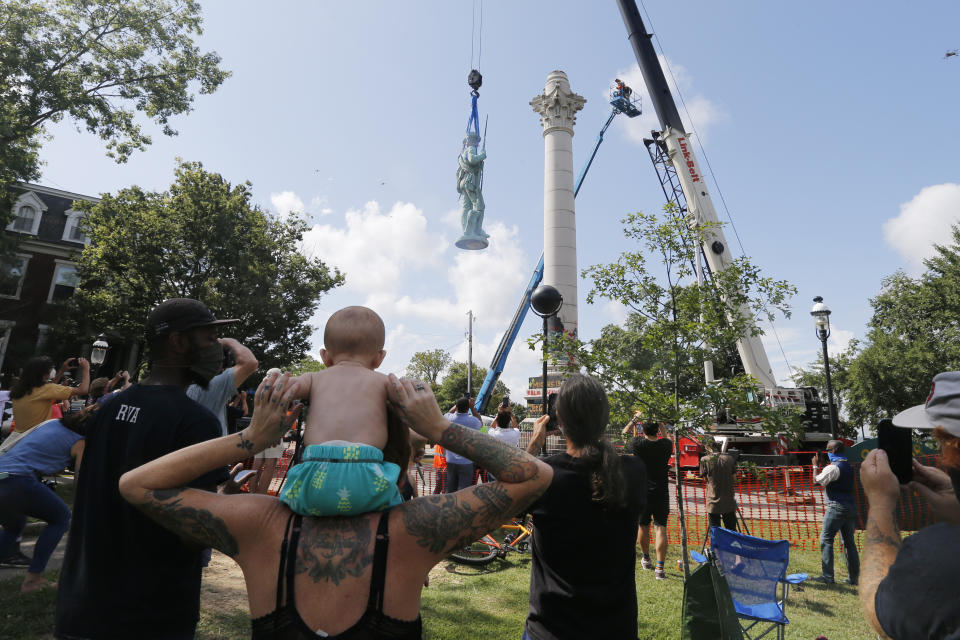 FILE - Spectators watch the removal of the Confederate Soldiers & Sailors Monument in Libby Hill Park in Richmond, Va., on July 8, 2020. At least 63 Confederate statues, monuments or markers have been removed from public land across the country since George Floyd’s death on May 25, making 2020 one of the busiest years yet for removals, according to an Associated Press tally. (AP Photo/Steve Helber, File)