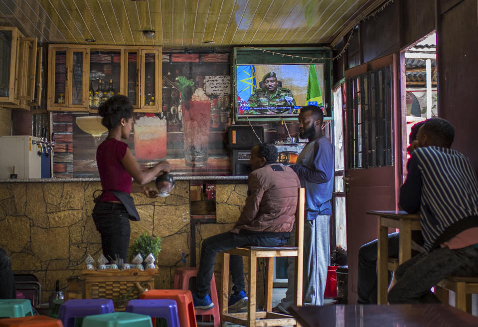 Ethiopians follow the news on television at a cafe in Addis Ababa, Ethiopia Sunday, June 23, 2019. Ethiopia's government foiled a coup attempt in a region north of the capital and the country's military chief was shot dead, the prime minister Abiy Ahmed said Sunday in a TV announcement. (AP Photo/Mulugeta Ayene)