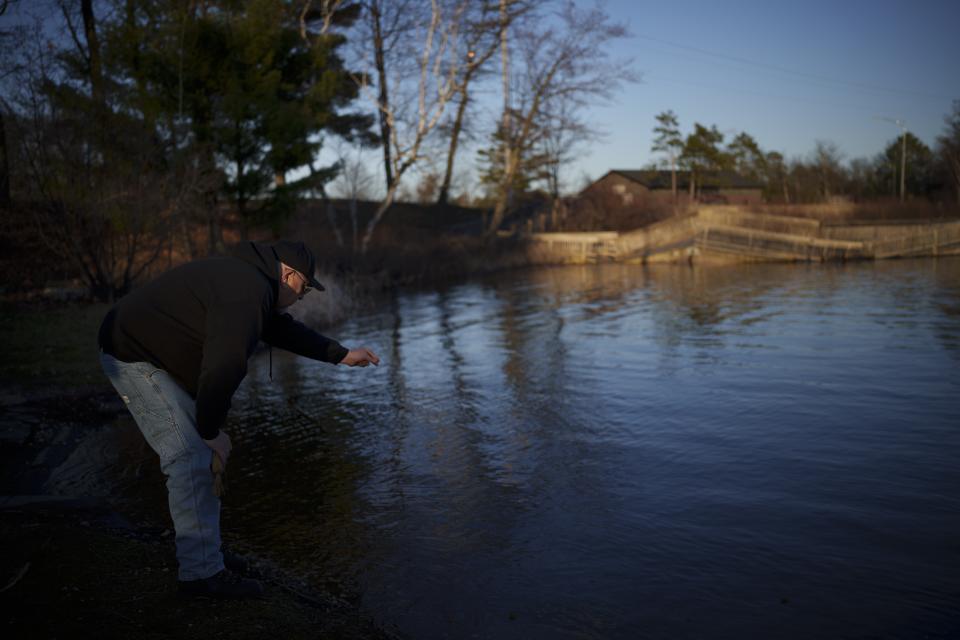 John Johnson, tribal president of the Lac du Flambeau Band of Lake Superior Chippewa Indians, places tobacco in the lake as an offering during a youth spearfishing event Saturday, April 20, 2024, in Lac Du Flambeau, Wis. (AP Photo/John Locher)