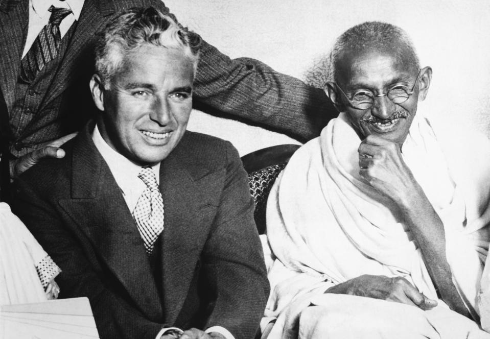 (Original Caption) Mahatma Gandhi, spiritual leader of India's millions of people, and Charles Chaplin, the American movie comedian, met recently in London and chatted for some time. Gandhi professed that he had not heard of Chaplin, but his associates assured him of the comedian's popularity and the meeting was arranged. They are shown here together at the residence of Dr. Katial in the London East End. Undated photograph. (Photo by George Rinhart/Corbis via Getty Images)