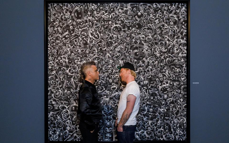 Williams and collaborator Ed Godrich with their artwork at the launch of their exhibition at Sotheby's in May this year - Getty