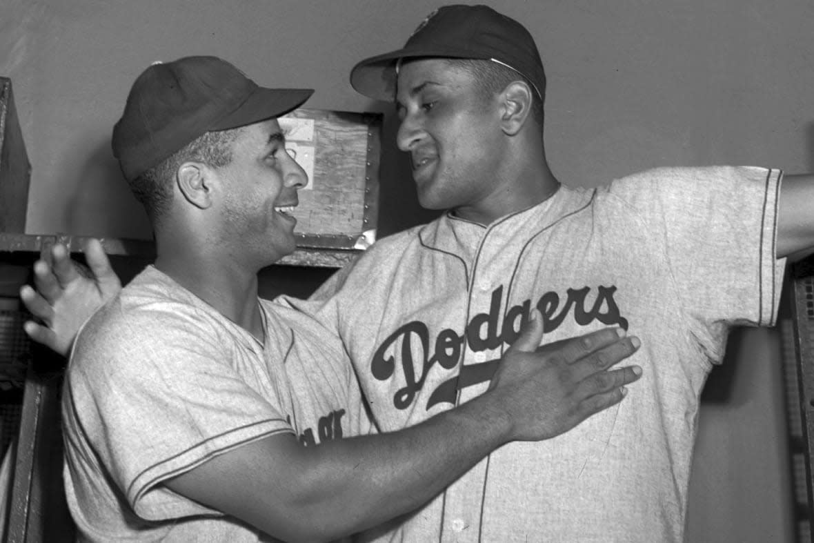 Brooklyn Dodgers catcher Roy Campanella, left, congratulates his battery mate, Don Newcombe, in the dressing room at the Polo Grounds in New York on Sept. 2, 1949. (AP Photo/Matty Zimmern, File)