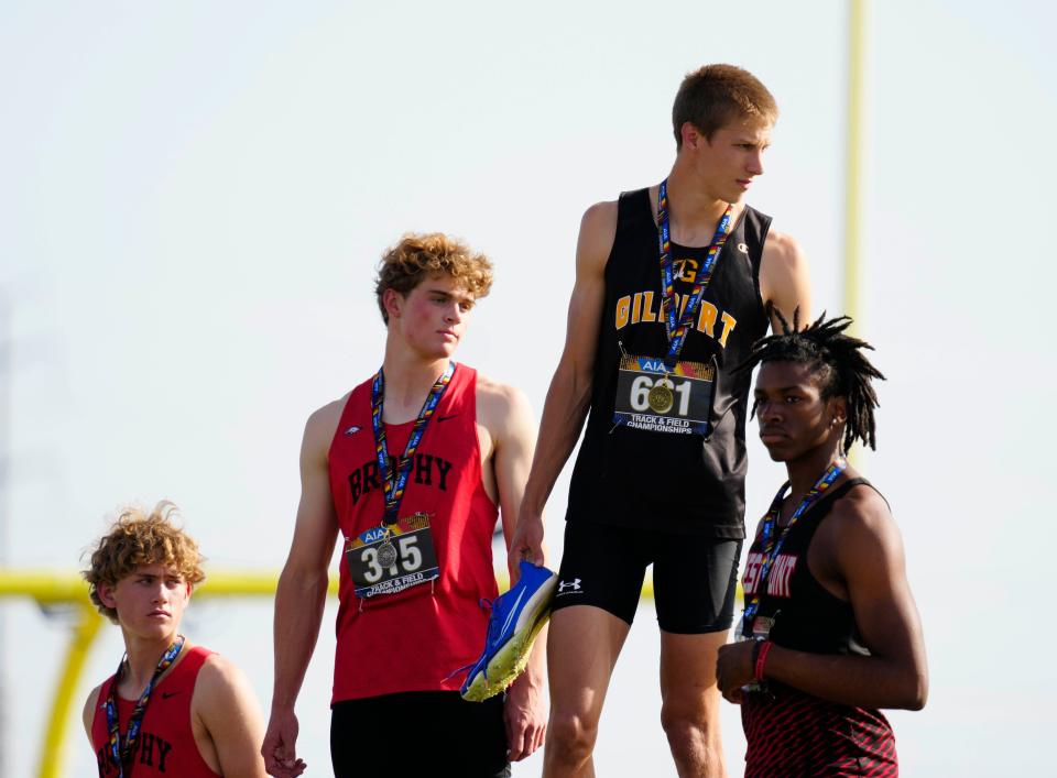 Gilbert’s Vance Nilsson stands atop the podium after winning the Boys 110m Hurdles against Brophy Prep’s Jack Sebald (center) and William DeSpong (L) and West Pointe’s Bellemy Amina-Harris (R) during the Arizona State Track and Field Championships at Red Mountain High School on Saturday, May 4, 2024.