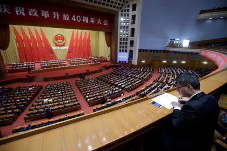 An official takes notes at an event marking the 40th anniversary of China's "reform and opening up" at the Great Hall of the People in Beijing, China December 18, 2018. REUTERS/Jason Lee