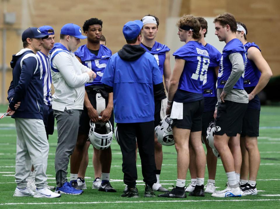 BYU QBs gather with coaching staff at the end of opening day of spring football camp at the BYU Indoor Practice Facility.