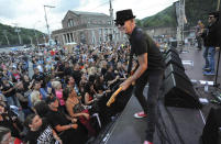 FILE - In this June 23, 2018, file photo, Mark Kendall, center, with the band Great White, performs on the Train Station stage during the 21st Annual Thunder in the Valley motorcycle rally in Johnstown, Pa. Metal band Great White has apologized for performing at an outdoor North Dakota concert where the crowd did not wear masks despite the ongoing threat of the coronavirus. The band drew criticism on social media after the performance Thursday, July 9, 2020, as part of the “First on First: Dickinson Summer Nights” concert series in Dickinson, in the southwest of the state. (John Rucosky/The Tribune-Democrat via AP, File)