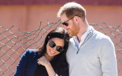 Harry and Meghan take a moment while watching a football match - Credit: Samir Hussein