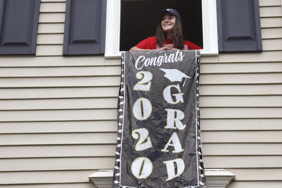 In this June 1, 2020 photo, high school graduate Lizzie Quinlivan poses at her home in Hingham, Mass. Quinlivan has opted to attend closer-to-home Georgetown instead of colleges on the west coast which were on her original wish-list. As students make college plans for this fall, some U.S. universities are seeing surging interest from in-state students looking to stay closer to home amid the coronavirus pandemic. (AP Photo/Elise Amendola)