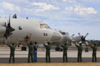 Japan Maritime Self-Defense Force personnel wave to their P-3C Orion as it taxis from the Royal Australian Air Force Pearce Base to commence a search for possible debris from the missing Malaysia Airlines flight MH370, in Perth, Australia, Monday, March 24, 2014. Satellite images released by Australia and China had earlier identified possible debris in an area that may be linked to the disappearance of the flight on March 8 with 239 people aboard. (AP Photo/Paul Kane, Pool)