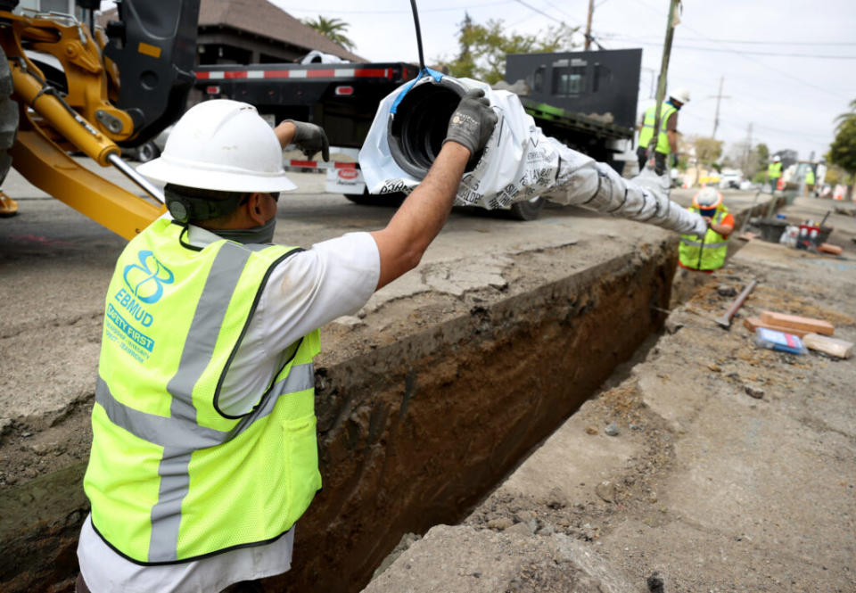  Workers with East Bay Municipal Utility District (EBMUD) install a new water pipe on April 22, 2021 in Oakland, California. (Photo by Justin Sullivan/Getty Images)