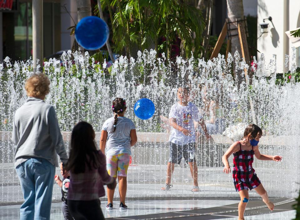 Children play in the Water Pavilion West Palm fountain, designed by Berlin-based Jeppe Hein, in The Square.