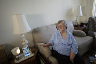 Joyce Loazia interacts with ElliQ, left, a tabletop device that uses artificial intelligence to conduct human-like conversations, during an interview in her apartment in a senior community in Coral Springs, Fla., Tuesday, Dec. 5, 2023. Loazia is among the first in the country to receive the robot ElliQ, whose creators, Intuition Robotics, and senior assistance officials say is the only device using artificial intelligence specifically designed to lessen the loneliness and isolation experienced by many older Americans. (AP Photo/Rebecca Blackwell)