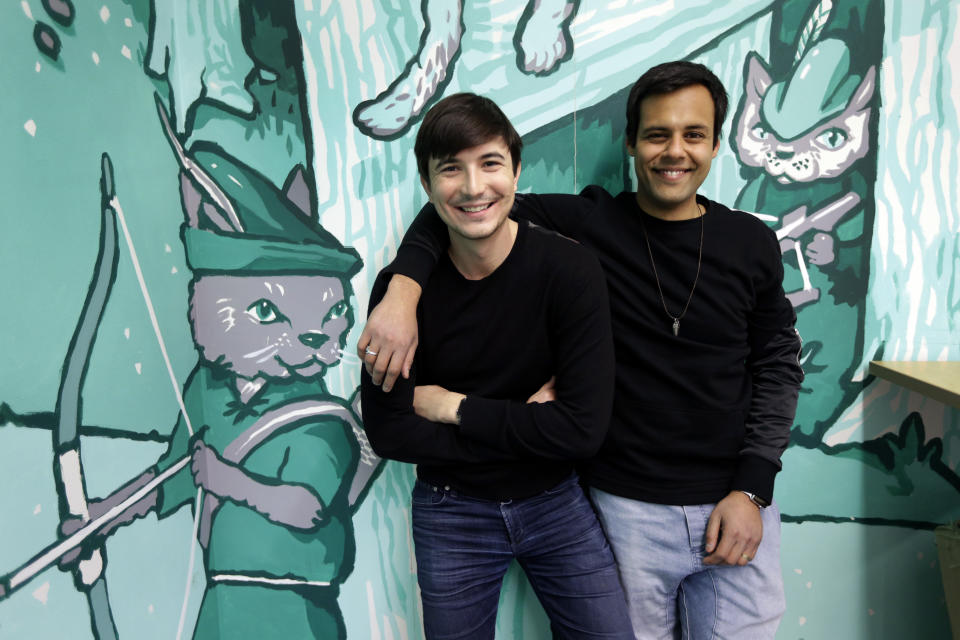 In this Wednesday, Dec. 2, 2015, photo, Robinhood co-founders Vlad Tenev, left, and Baiju Bhatt pose at company headquarters in Palo Alto, Calif. Robinhood is a stock brokerage that does not charge any commissions for its more than 1 million customers to buy and sell shares. "During the next 10 years, we are going to create an international company that will be like nothing the financial services industry has ever seen," says Bhatt. (AP Photo/Ben Margot)