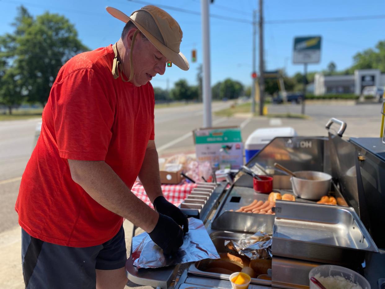 Jim Sirks wraps up a coney dog at the White Star Coneys stand in the parking lot of Bailey Park Supermarket in Pennfield Township in Thursday, June 30, 2022.