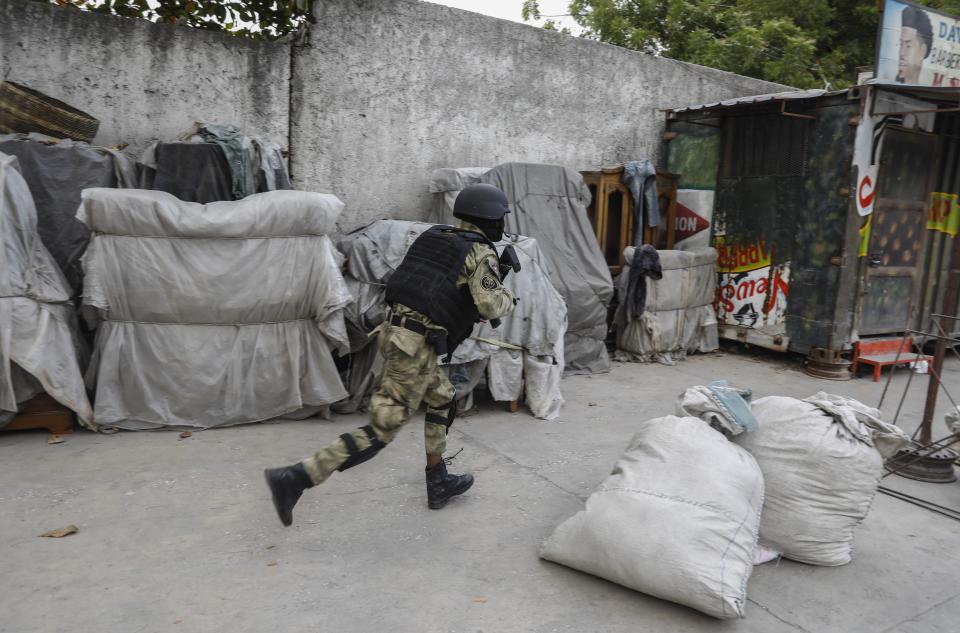 A police officer runs during an anti-gang operation at the Portail neighborhood of Port-au-Prince, Haiti, Thursday, Feb. 29, 2024. Gunmen shot at the international airport and other targets in a wave of violence that forced businesses, government agencies and schools to close early. (AP Photo/Odelyn Joseph)