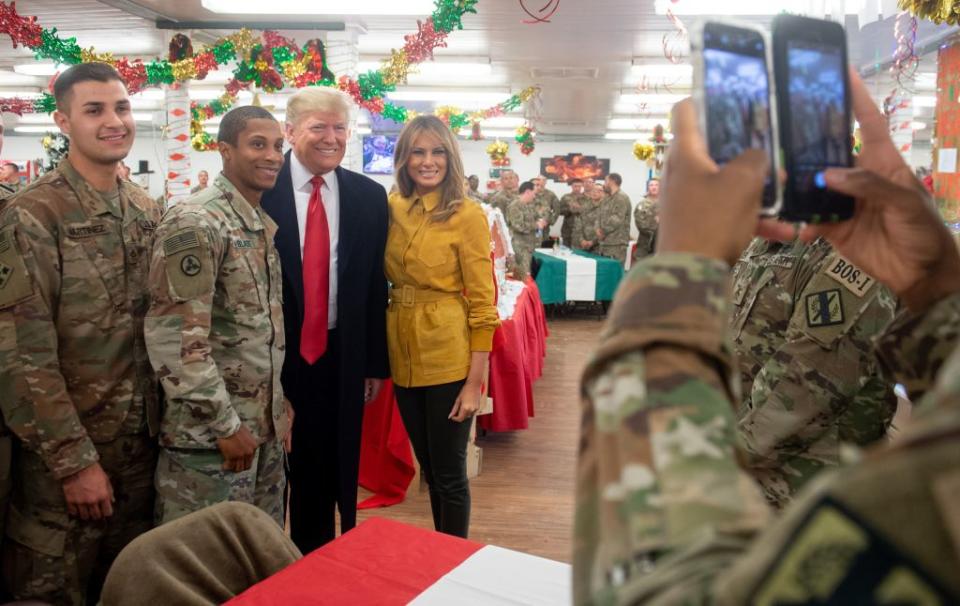 US President Donald Trump and First Lady Melania Trump take photos with members of the US military during an unannounced trip to Al Asad Air Base in Iraq on December 26, 2018.