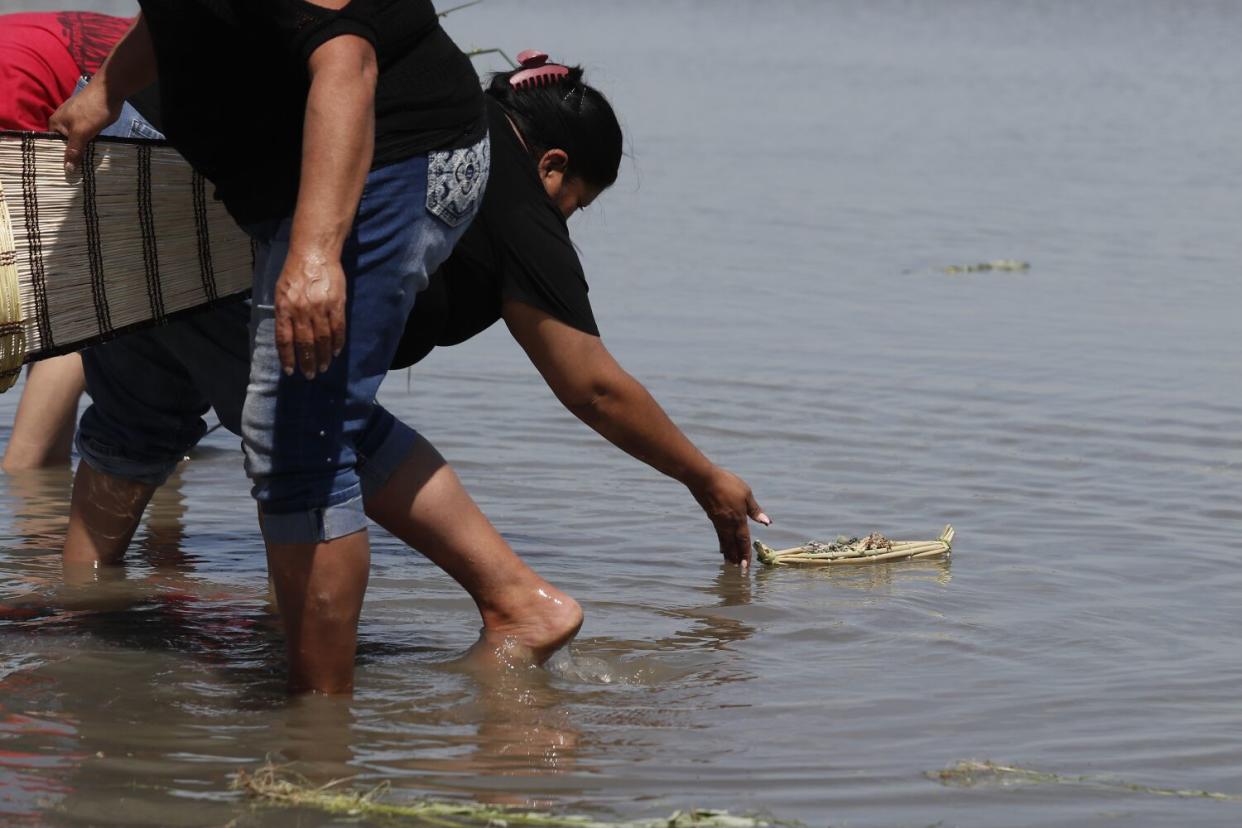 A boat made of tule reeds gets launched during a ceremony celebrating the rebirth of Tulare Lake near Stratford, Calif.