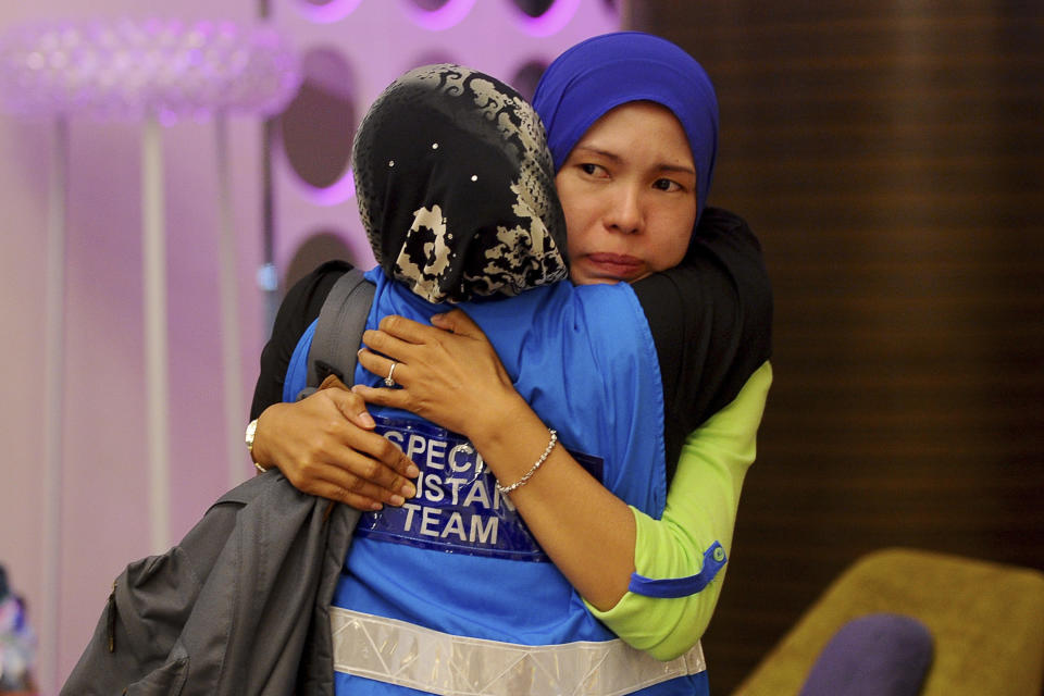 A family member, right, of passengers aboard a missing Malaysia Airlines plane is embraced by a member of Special Assistance Team at a hotel in Putrajaya, Malaysia, Tuesday, March 25, 2014. Malaysia said Tuesday that it has narrowed the search for a downed jetliner to an area the size of Texas and Oklahoma in the southern Indian Ocean, while Australia said improved weather would allow the hunt for possible debris from the plane to resume. (AP Photo/Joshua Paul)