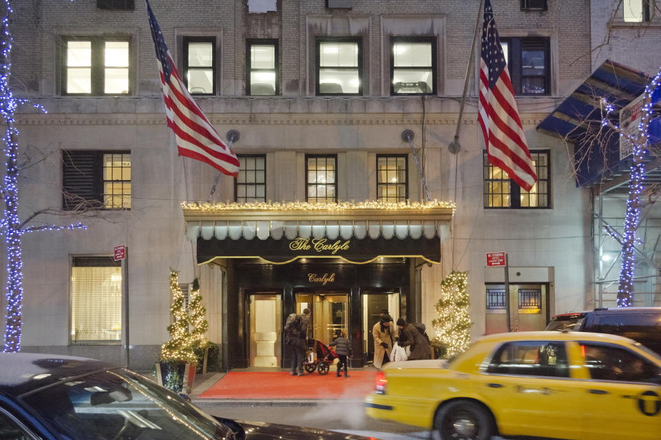 New York, USA - January 25, 2013: The Carlyle is a  luxury hotel located at 35 East 76th Street on Madison Avenue, it is both rental rooms and suites hotel and privately owned residence. People in front of the entrance, the doorman is helping a guest, cars are passing on the street and it is snowing.