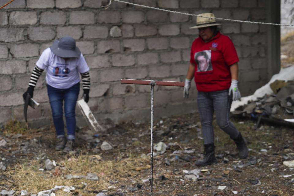 A relative searches for missing loved ones in a clandestine grave in Zumpango, Mexico, Friday, April 19, 2024. Hundreds of collectives searching for missing loved ones fanned out across Mexico on Friday as part of a coordinated effort to raise the profile of efforts that are led by the families of the tens of thousands of missing across Mexico without support from the government. (AP Photo/Marco Ugarte)