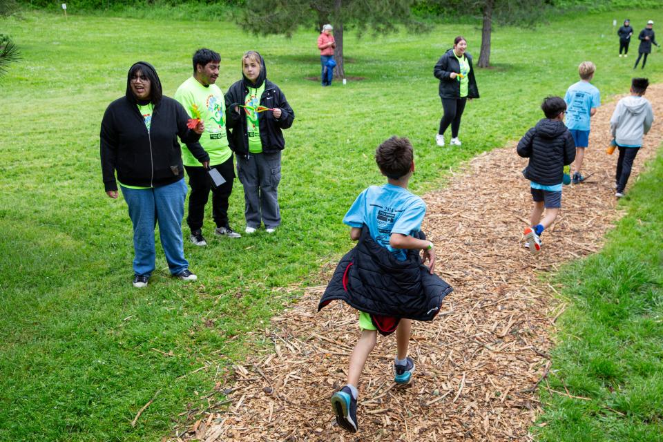 Alicia Chase and Almir Martinez from Chemeketa Community College, and Karla Munez-Vela from North Salem High School, cheer on third grade boys during the 2024 Awesome 3000 at Bush's Pasture Park.