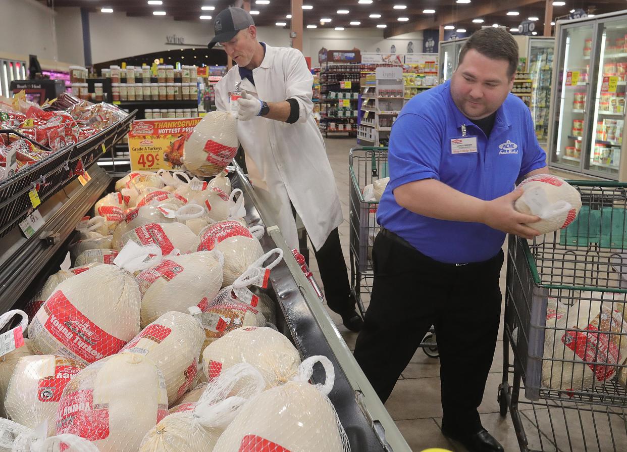 James Herceg, left, meat manager at Acme Fresh Market, and Lance Brown, grocery manager, stock turkeys Monday at the store in Fairlawn.