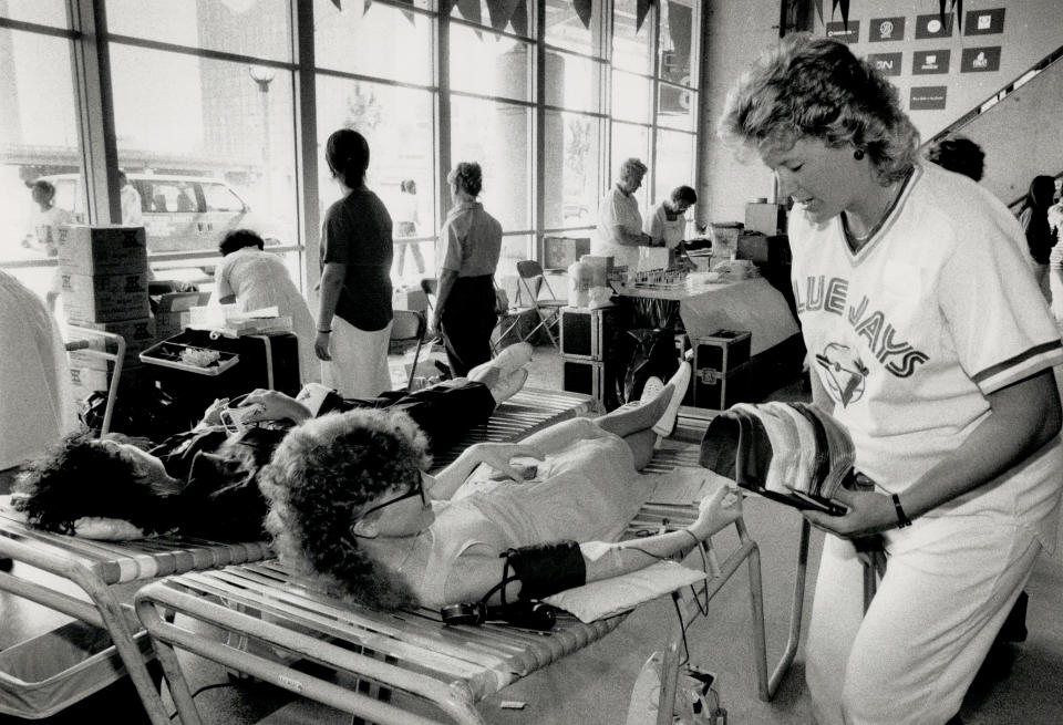 July 18,1989: Donating in the dome. Kathy Henke, wife of Blue Jay hurler Tom Henke, puts in some relief work of her own, handing out souvenir hats to donors at the SkyDome blood clinic. (Photo by Ron Bull/Toronto Star via Getty Images)