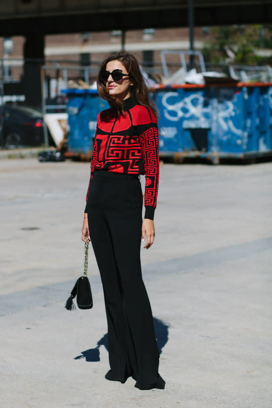 <p>What’s black, white (kind of?) and red all over? This chick; she’s wearing a Versace top, oversized sunnies ,and high-waisted trousers. </p>