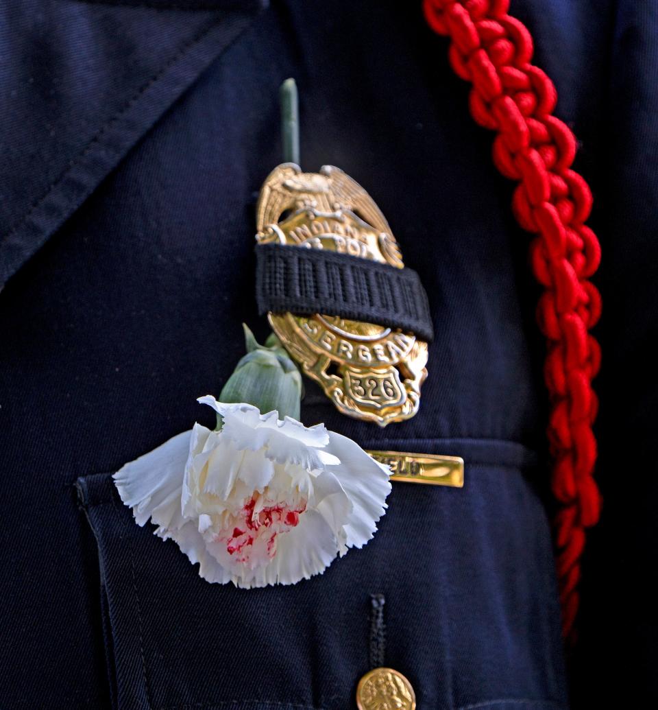 White carnations with a red spot are worn during the day of the funeral of Trooper Aaron Smith Friday, July 7, 2023. The white carnation symbolizes a good life and career and the red dot symbolizes the blood shed by a law enforcement officer killed in the line of duty. The 33-year-old Indiana State Police Trooper was killed June 28, 2023 when he tried to stop a fleeing driver by placing stop sticks on Ronald Reagan Parkway. The driver swerved and hit him.