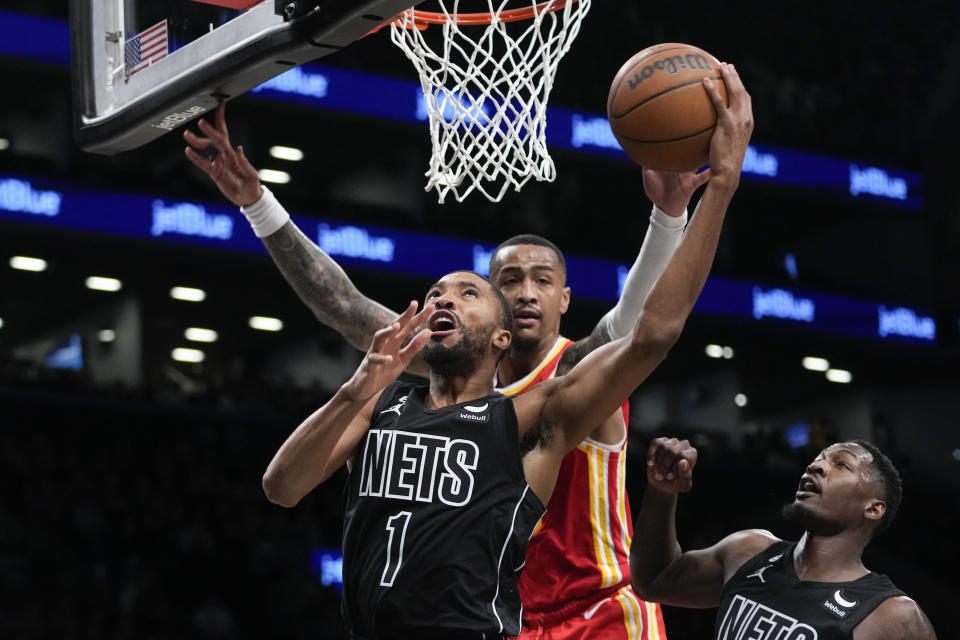 Brooklyn Nets forward Mikal Bridges (1) goes to the basket past Atlanta Hawks forward John Collins during the second half of an NBA basketball game Friday, March 31, 2023, in New York. The Nets won 124-107. (AP Photo/Mary Altaffer)