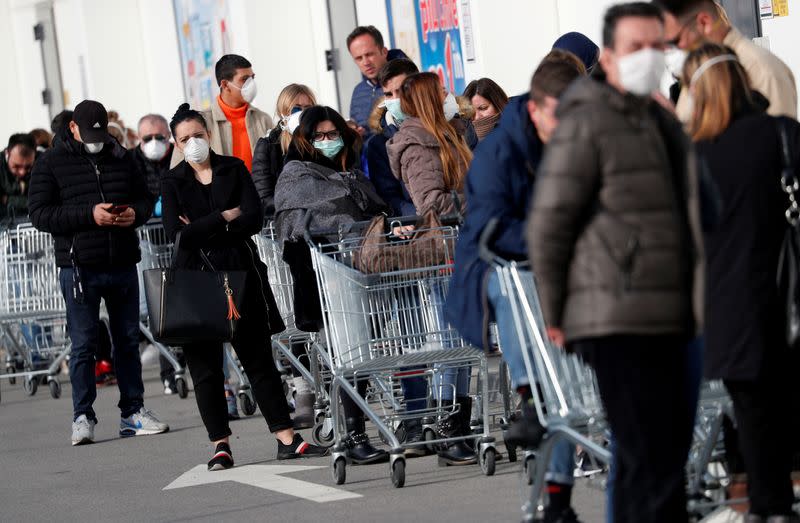 FILE PHOTO: People queue at a supermarket outside the town of Casalpusterlengo