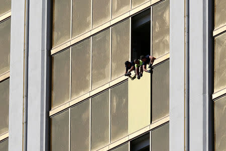 FILE PHOTO: Workers board up a broken window at the Mandalay Bay hotel, where shooter Stephen Paddock conducted his mass shooting along the Las Vegas Strip, in Las Vegas, Nevada, U.S., October 6, 2017. REUTERS/Chris Wattie/File Photo