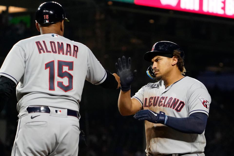 Guardians first baseman Josh Naylor, right, is congratulated by first base coach Sandy Alomar Jr. after hitting a two-run single against the Cubs during the 10th inning, Sunday, July 2, 2023, in Chicago.