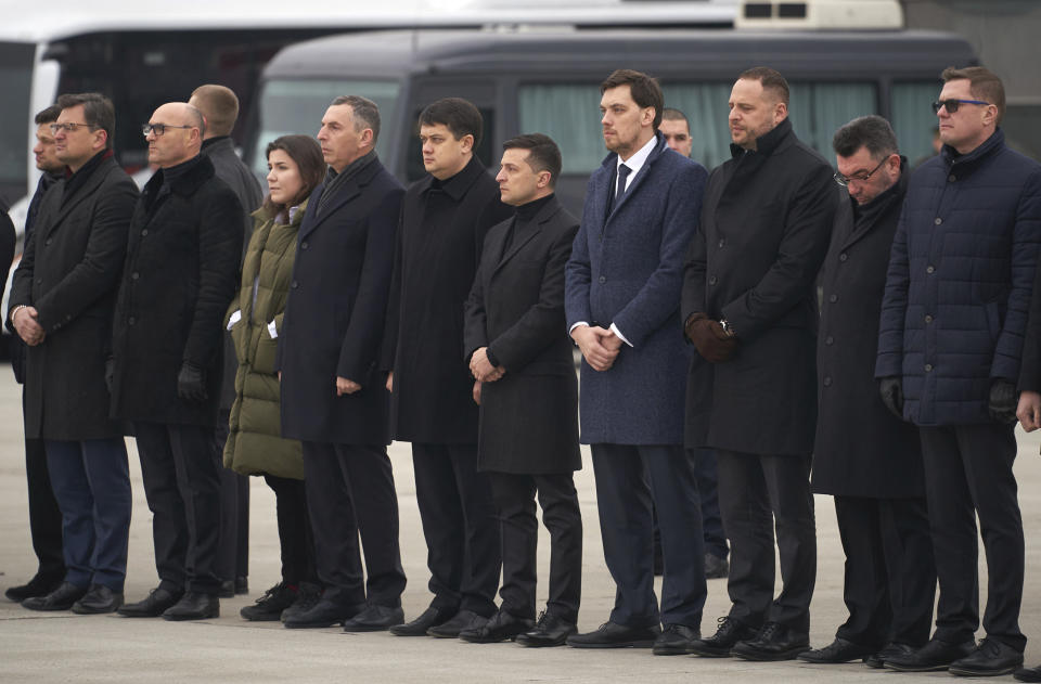 In this photo provided by the Ukrainian Presidential Press Office, Ukrainian President Volodymyr Zelenskiy, centre, and Ukraine's Prime Minister Oleksiy Honcharuk, centre right, seen before a memorial ceremony at Borispil international airport outside Kyiv, Ukraine, Sunday, Jan. 19, 2020. An Ukrainian passenger jet carrying 176 people has crashed just minutes after taking off from the Iranian capital's main airport on Jan. 8, 2020. (Ukrainian Presidential Press Office via AP)