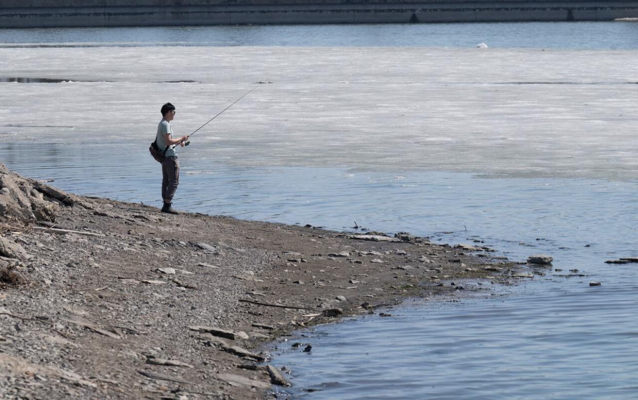 As the ice melts, someone casts a fishing line in Dows Lake in Ottawa in April 2023. This year's flu season has stretched on much longer than the last one, with wastewater readings remaining very high in the nation's capital. (Adrian Wyld/The Canadian Press - image credit)
