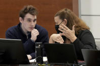 Marjory Stoneman Douglas High School shooter Nikolas Cruz speaks with paralegal Melissa Sly during a break in the penalty phase of Cruz's trial at the Broward County Courthouse in Fort Lauderdale, Fla., Thursday, Sept. 1, 2022. Cruz previously plead guilty to all 17 counts of premeditated murder and 17 counts of attempted murder in the 2018 shootings. (Amy Beth Bennett/South Florida Sun Sentinel via AP, Pool)