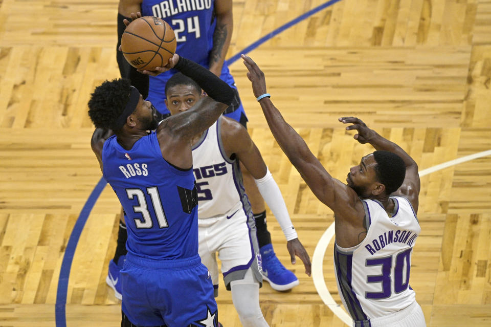 Orlando Magic guard Terrence Ross (31) shoots in front of Sacramento Kings guard De'Aaron Fox (5) and forward Glenn Robinson III (30) during the second half of an NBA basketball game Wednesday, Jan. 27, 2021, in Orlando, Fla. (AP Photo/Phelan M. Ebenhack)