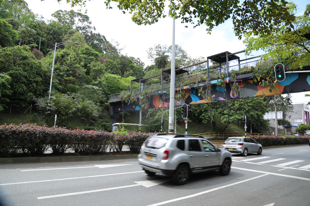 cars driving on the road in medellin, colombia near trees and plants