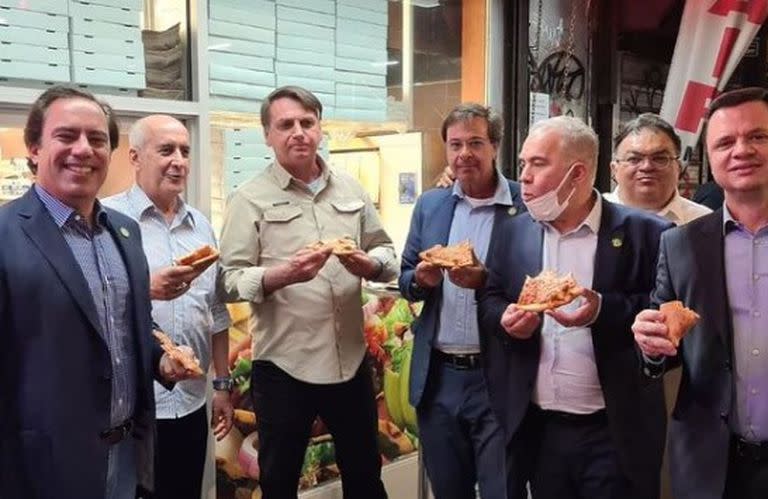 El presidente brasileño, Jair Bolsonaro, junto a su delegación, en Nueva York; Queiroga era el único con barbijo, en el mentón mientras cenaban una pizza