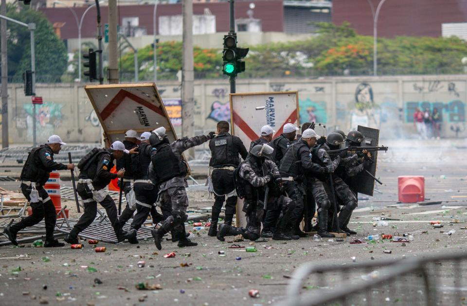 Riot police disperse fans of Flamengo football club taking part in a celebration parade, following the team's arrival from the Libertadores final, after some alleged theft incidents within the crowd, in Rio de Janeiro, Brazil on November 24, 2019. (Photo by Daniel RAMALHO / AFP) (Photo by DANIEL RAMALHO/AFP via Getty Images)