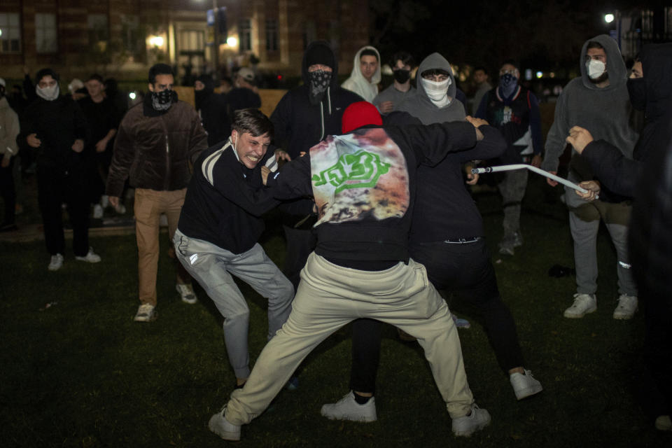 FILE - Demonstrators clash at an encampment at UCLA early Wednesday, May 1, 2024, in Los Angeles. Dueling groups of protesters have clashed at the University of California, Los Angeles, grappling in fistfights and shoving, kicking and using sticks to beat one another. (AP Photo/Ethan Swope, File)